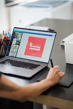 pexels photo 12902944 12902944 Person using a laptop and graphic tablet for digital design work in a home office.